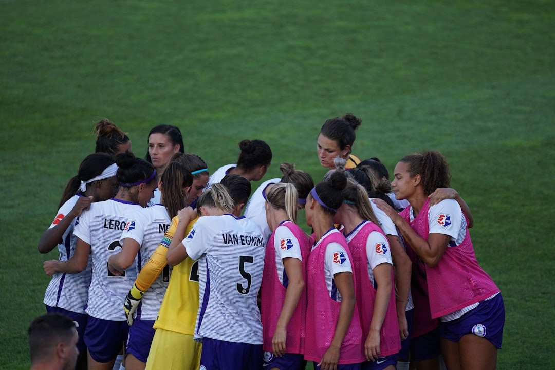 womens soccer team in a huddle on field